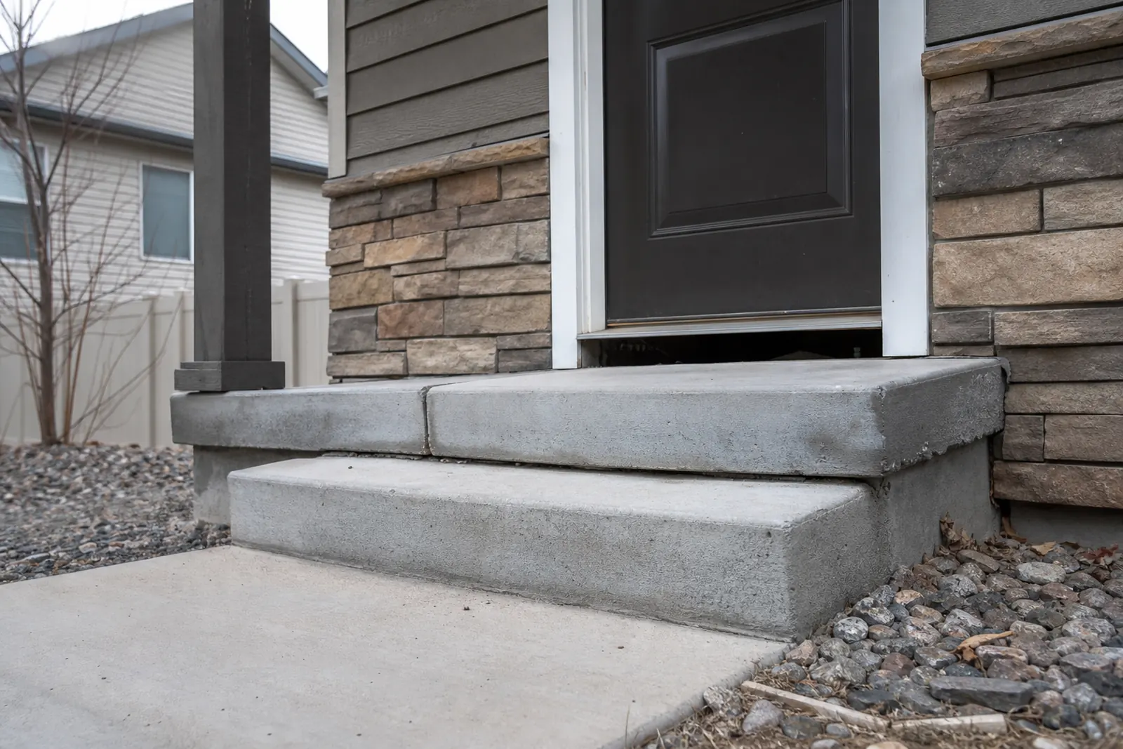 Concrete front steps that have settled and pulled away from the entry