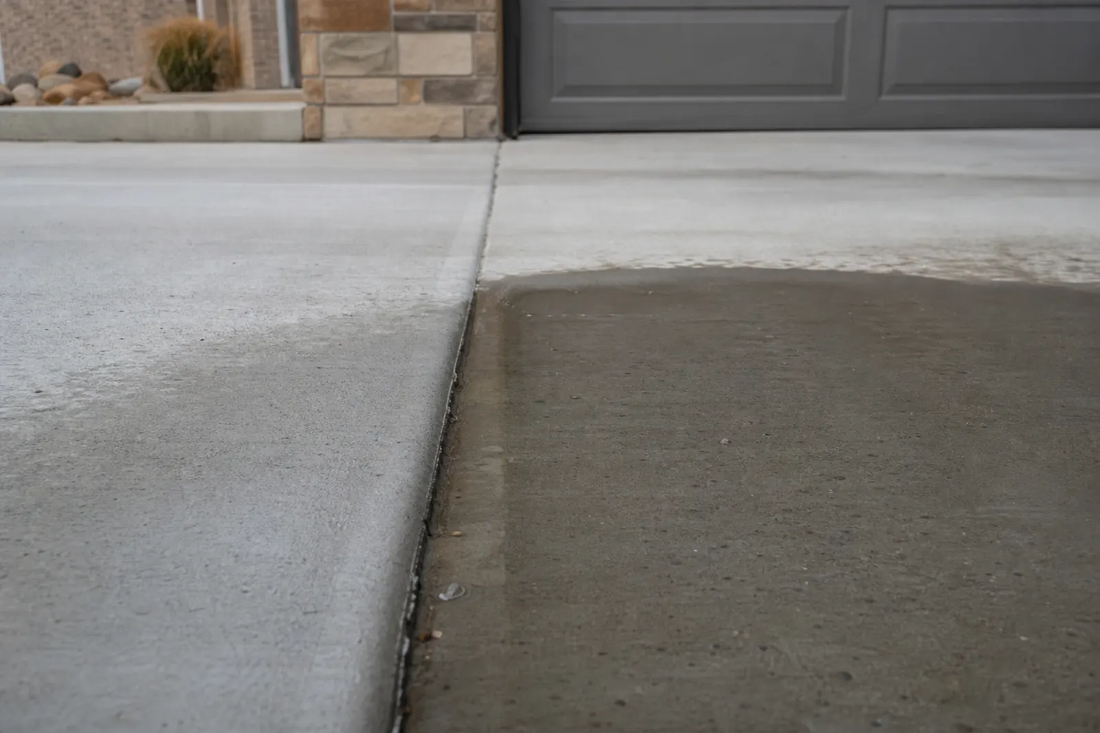 Water sitting in a driveway panel that has settled lower than the slab next to it