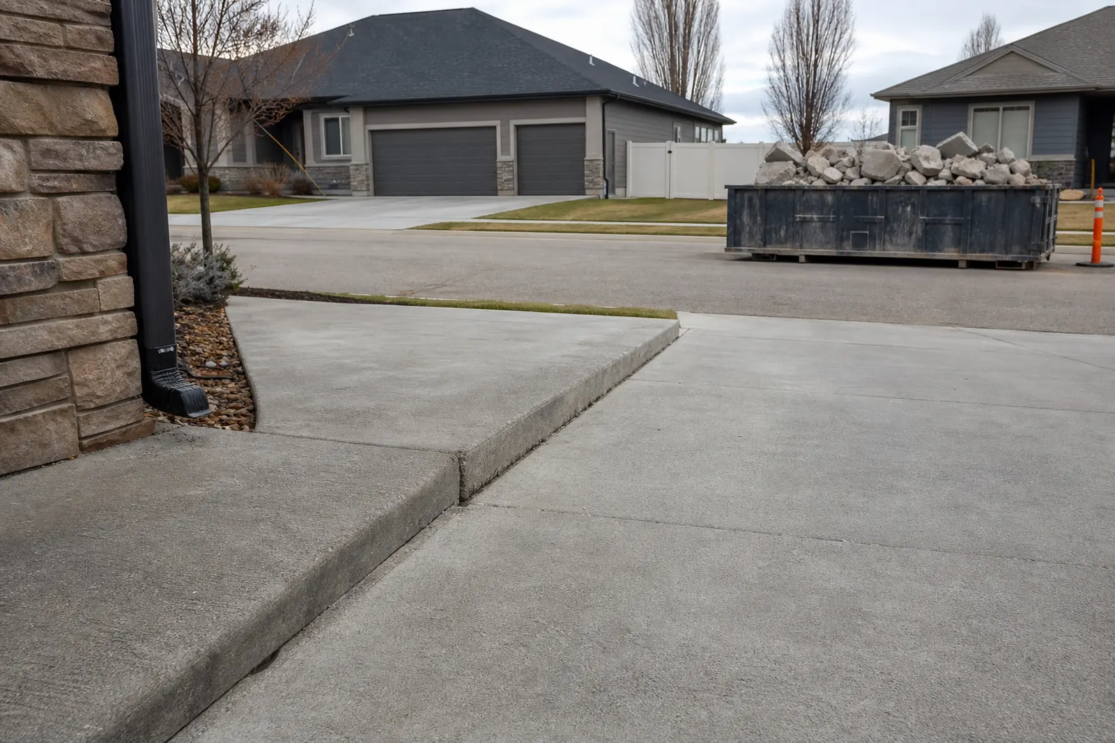 Settled walkway panel with a dumpster of broken concrete down the street