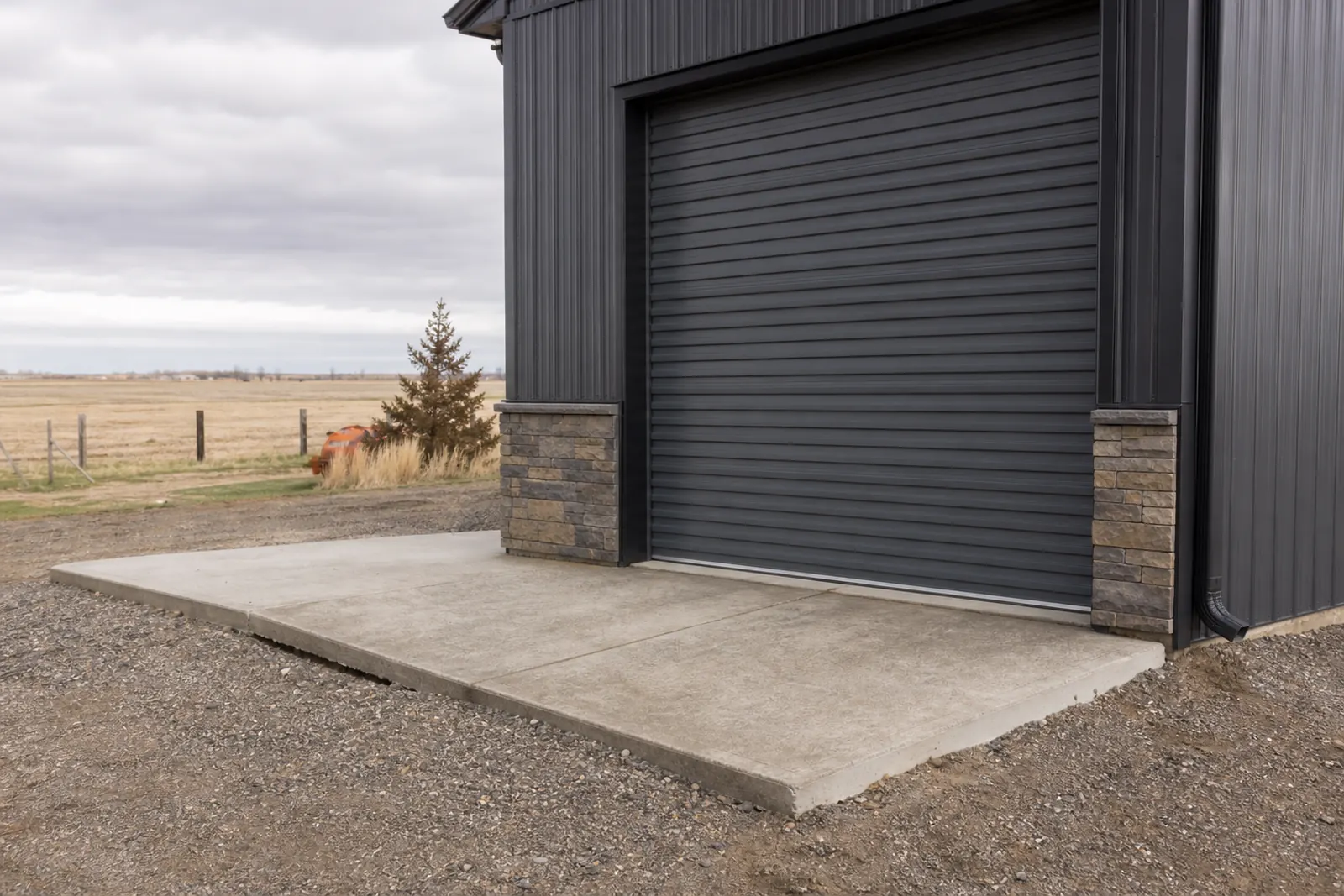 Concrete apron in front of a metal shop building on a rural property