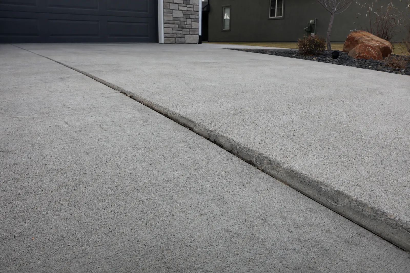 Driveway with a long crack where one side has sunk lower