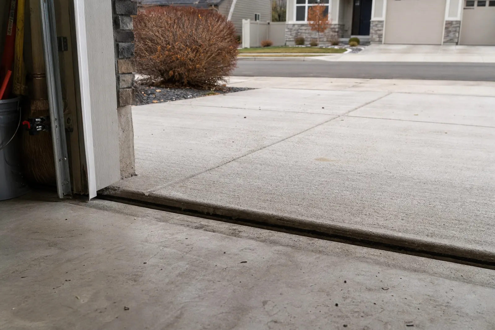 Driveway slab dropped below the garage floor, leaving a gap at the door