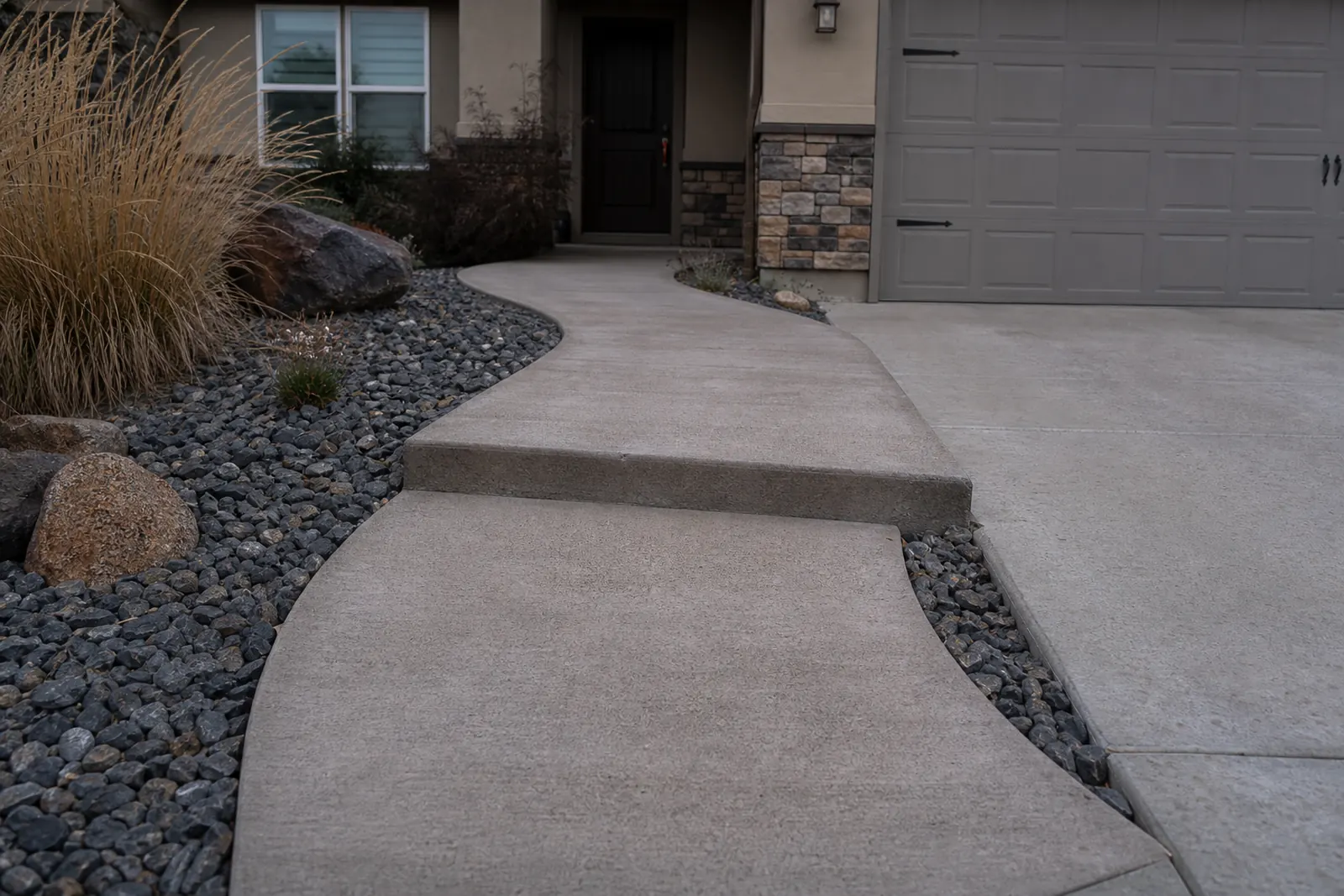 Curved front walkway with one section dropped below the next, leading to a garage